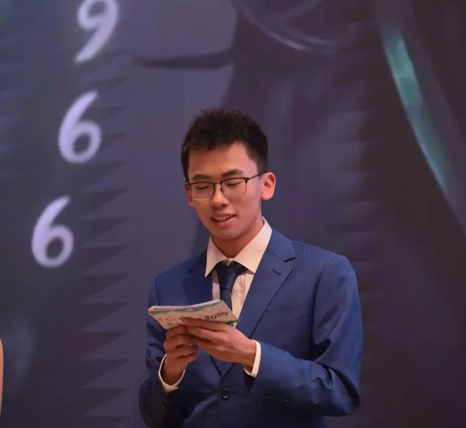Hosting a campus event in a blue suit with cue cards