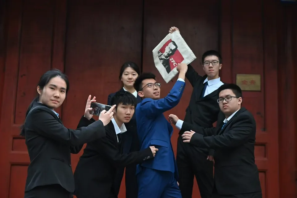 A playful student union group portrait with a ZFC tote bag