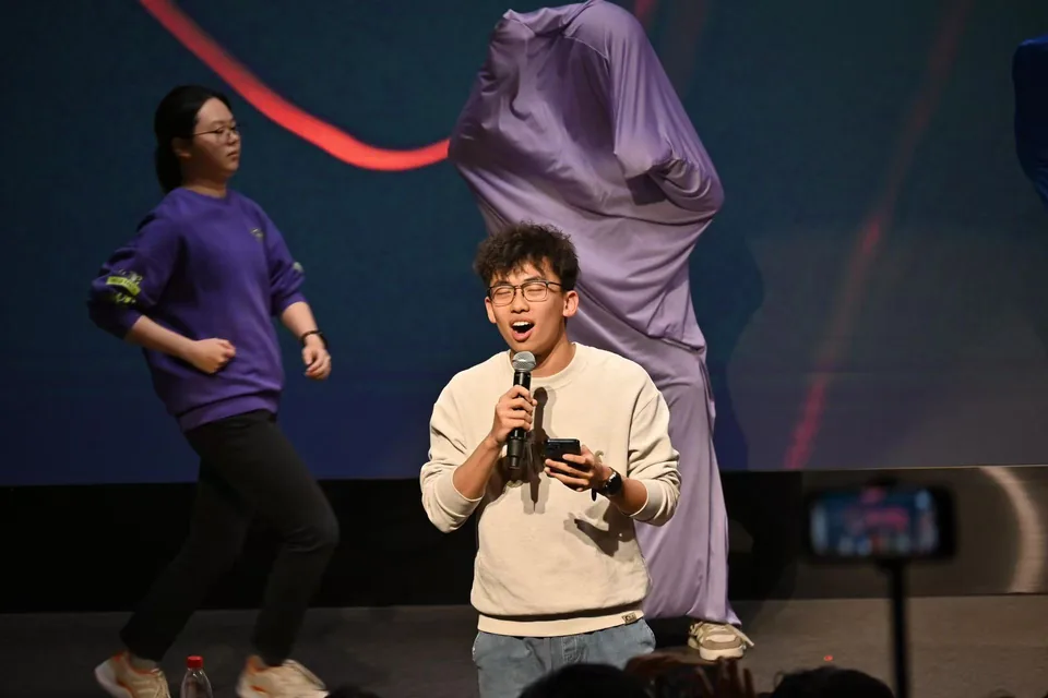 Holding a microphone on stage at a campus performance